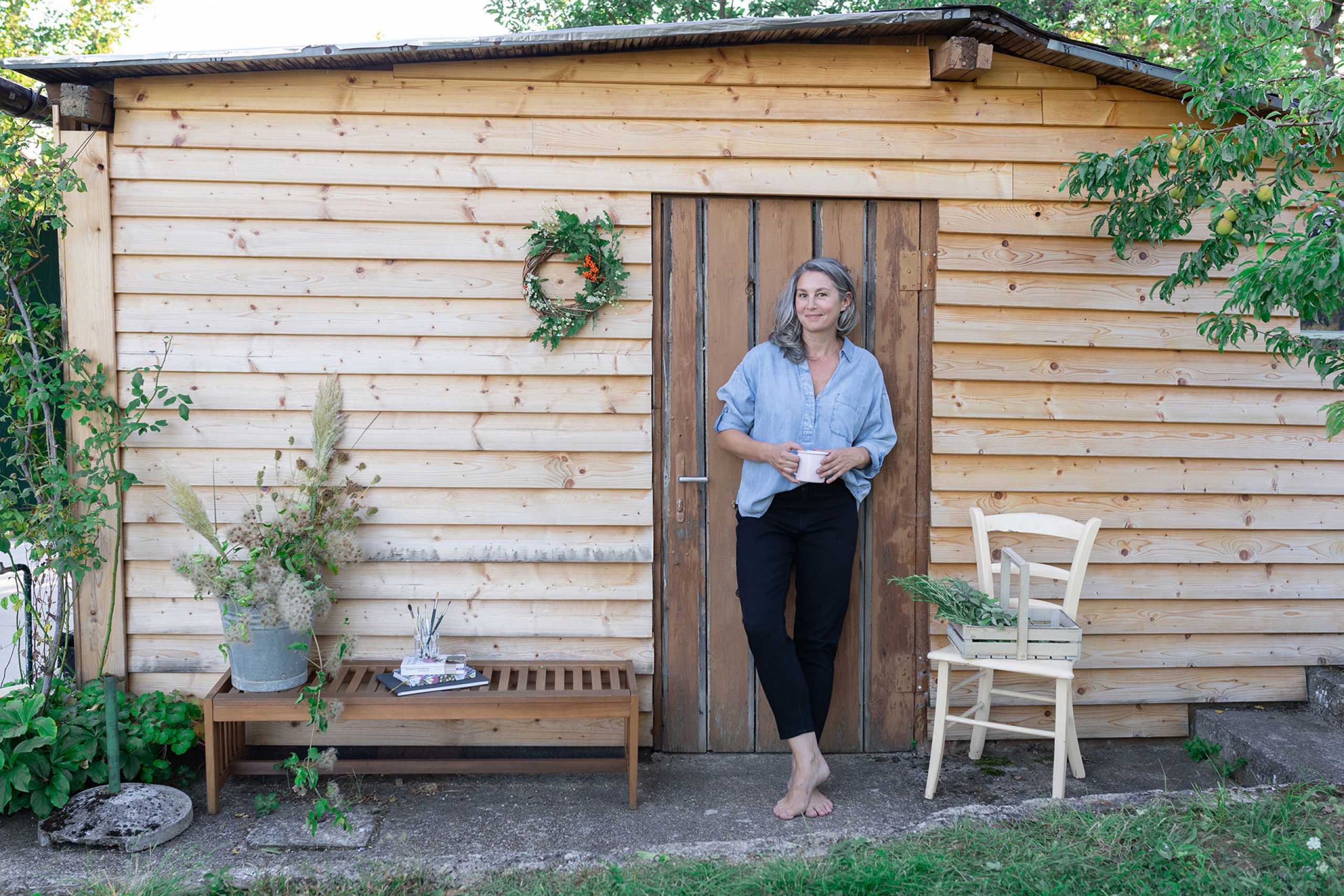 Sylvia Fischer entspannt vor ihrer Gartenhütte